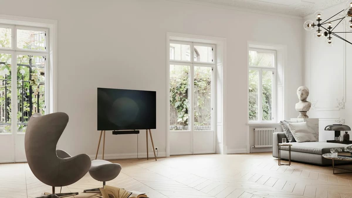 Heller, eleganter Wohnraum mit freistehendem Fernseher auf einem Stativgestell