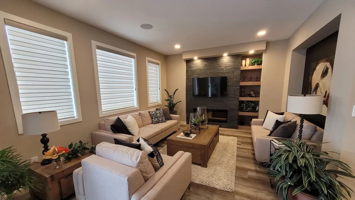 Helles, modernes Wohnzimmer mit wandmontiertem Fernseher, Sideboard und großen Fenstern