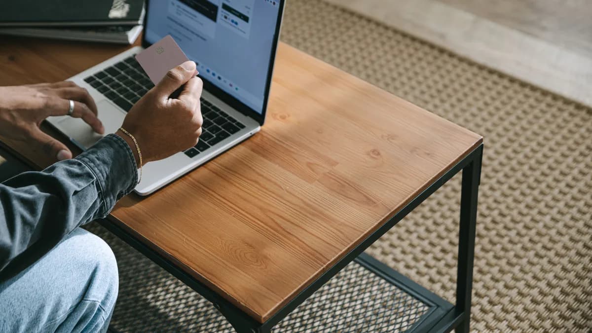 Hände tippen auf einer Laptop-Tastatur, im Hintergrund ein unscharfer, generischer Bestellbildschirm